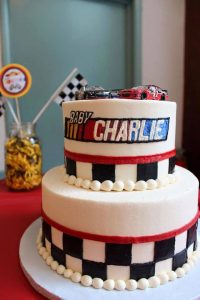 racing themed birthday cake with two cars on top