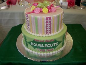 Two tier round cake with each tier having different design for twins