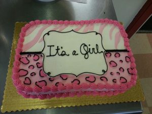 pink gender reveal cake with its a girl message