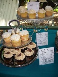 table with two platters of vanilla and chocolate cupcakes