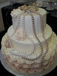 powder pink and white cake with pearls and two small crowns on top