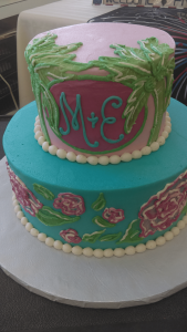 Pink and teal cake with initials and palm trees