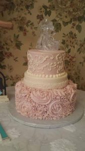 delicate pink and white two tier cake with glass topper