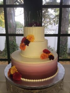 Purple to white Ombre wedding cake with yellow and orange carnations