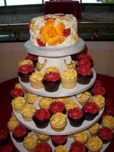 red and yellow wedding cupcake tower with pop of orange on the top