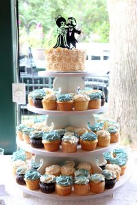 cup cake stand with wedding cake on top layer