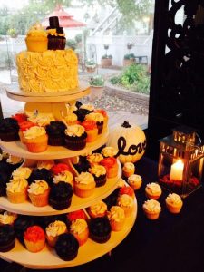 cup cake stand with wedding cake on top and cupcake bride/groom topper