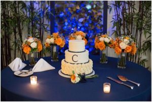 white three tier wedding cake with orange and white flowers on the background