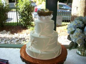 delicate four tier wedding cake with the bird nest topper