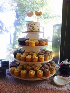 wedding cupcake tower with two lovebirds as a topper