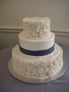 White wedding cake with creme roses