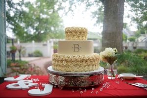 Ivory monogram wedding cake with creme roses